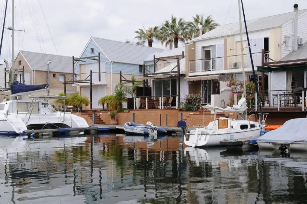 Waterfront row of modern houses with boats moored at private jetty