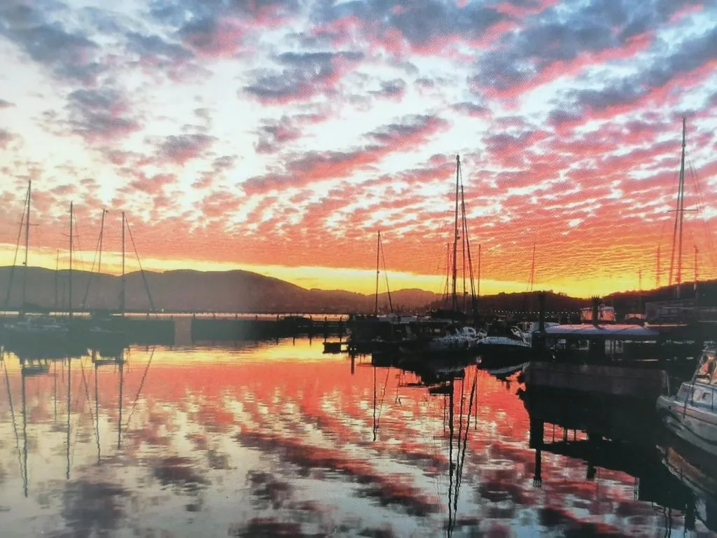 Stunning sunset over Knysna lagoon with moored sailboats and mountains