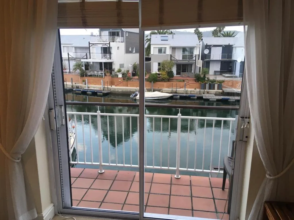 Waterfront canal view with boats and residential buildings from balcony
