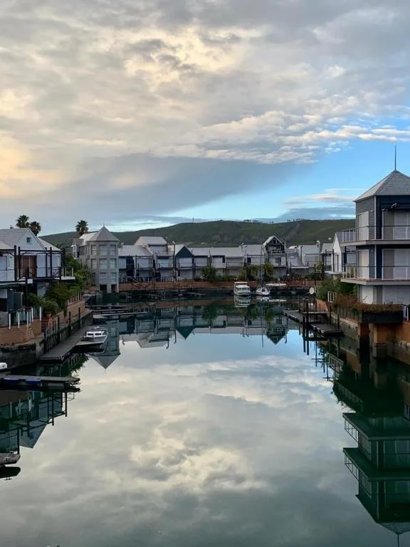 Serene waterfront view of Knysna Heads with historic buildings reflected in calm water