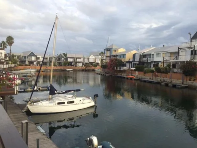 Waterfront village with sailboat moored in calm canal waters