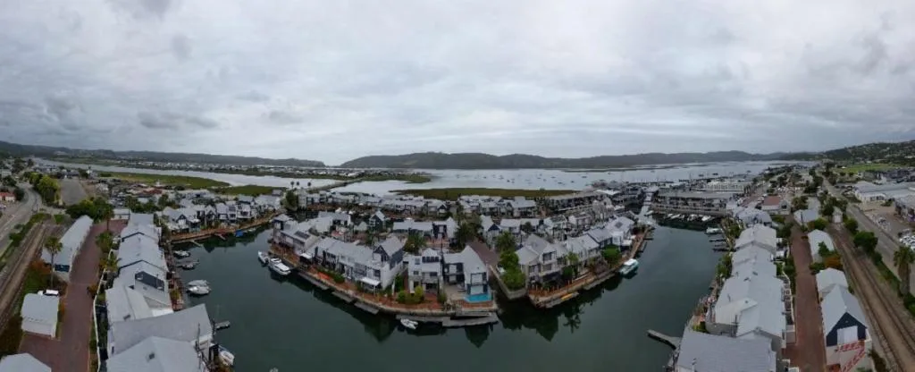 Aerial view of Knysna waterfront with lagoon, boats, and surrounding hills