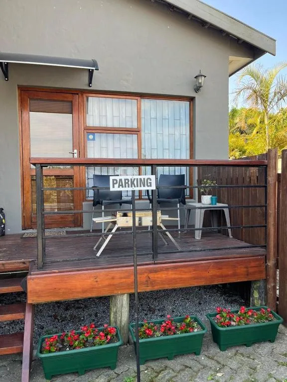 Wooden deck with outdoor seating, black chairs, and flowering planters