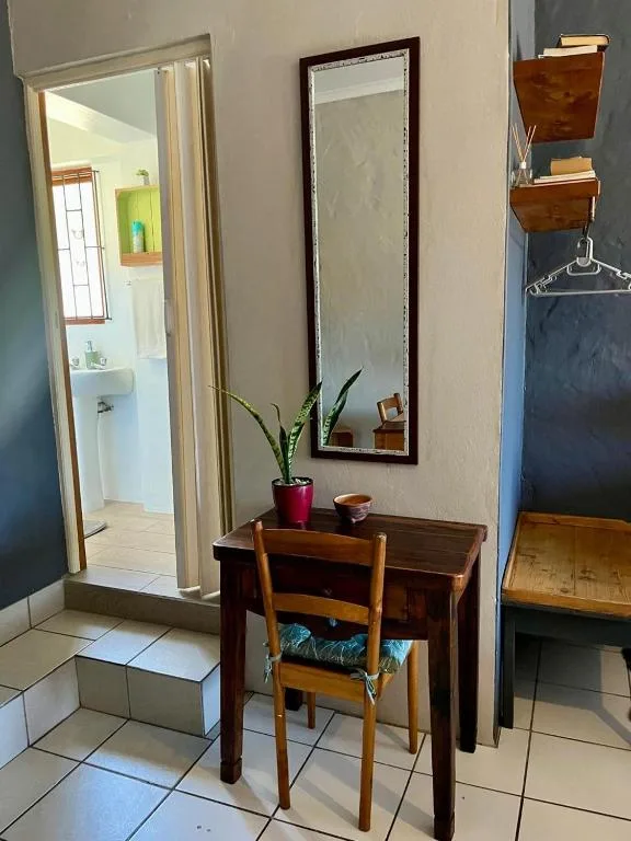 Wooden desk with mirror and potted plant in hallway