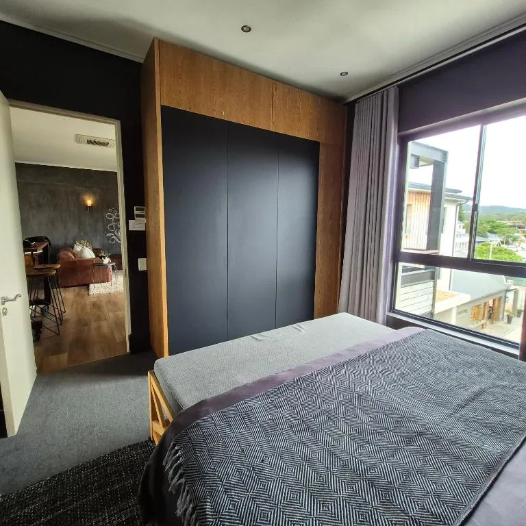 Modern bedroom with large bed, wardrobe, and scenic mountain view windows