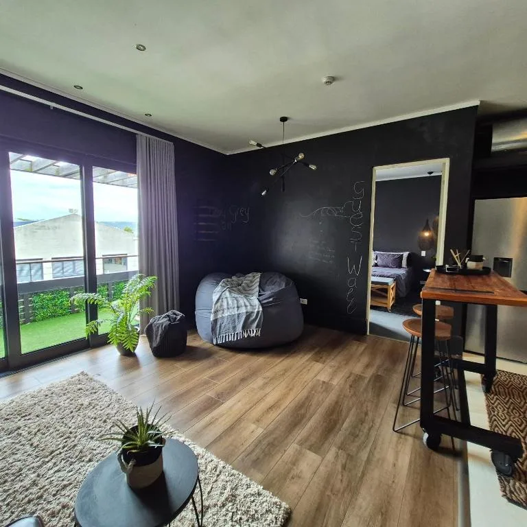 Modern lounge with black accent wall, bean bag seating, and garden views