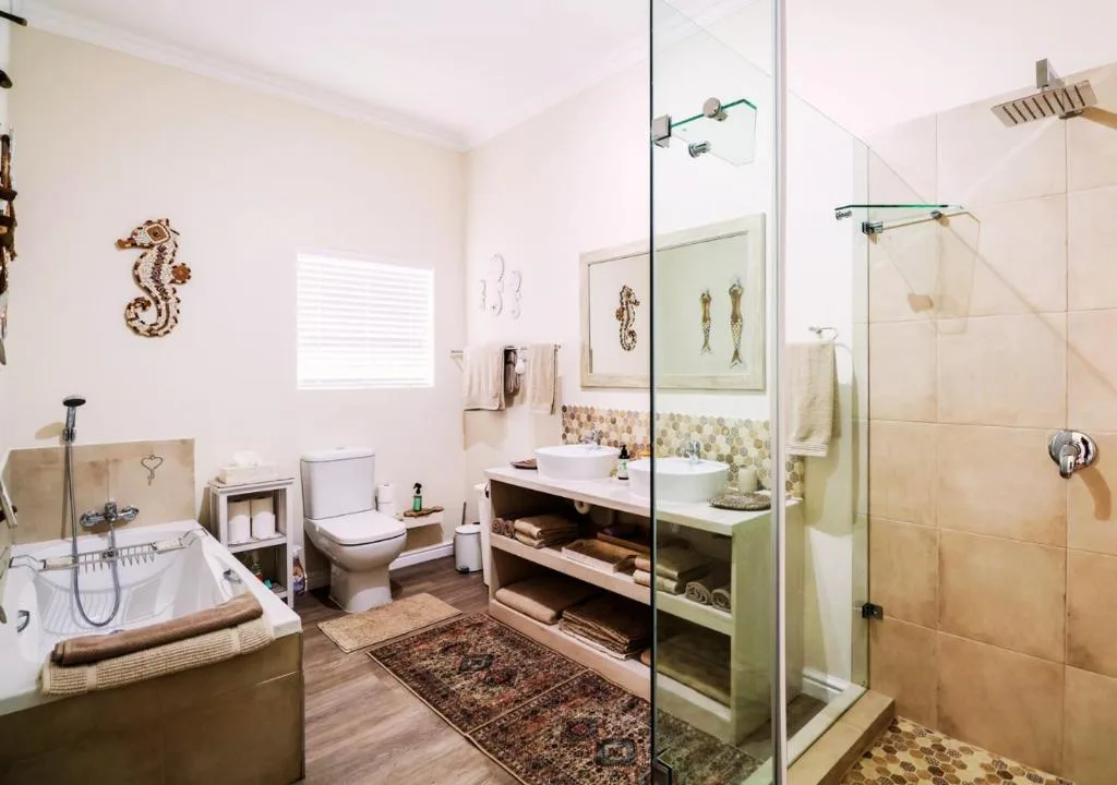 Spacious bathroom with soaking tub, separate shower, toilet, and dual vanity sink