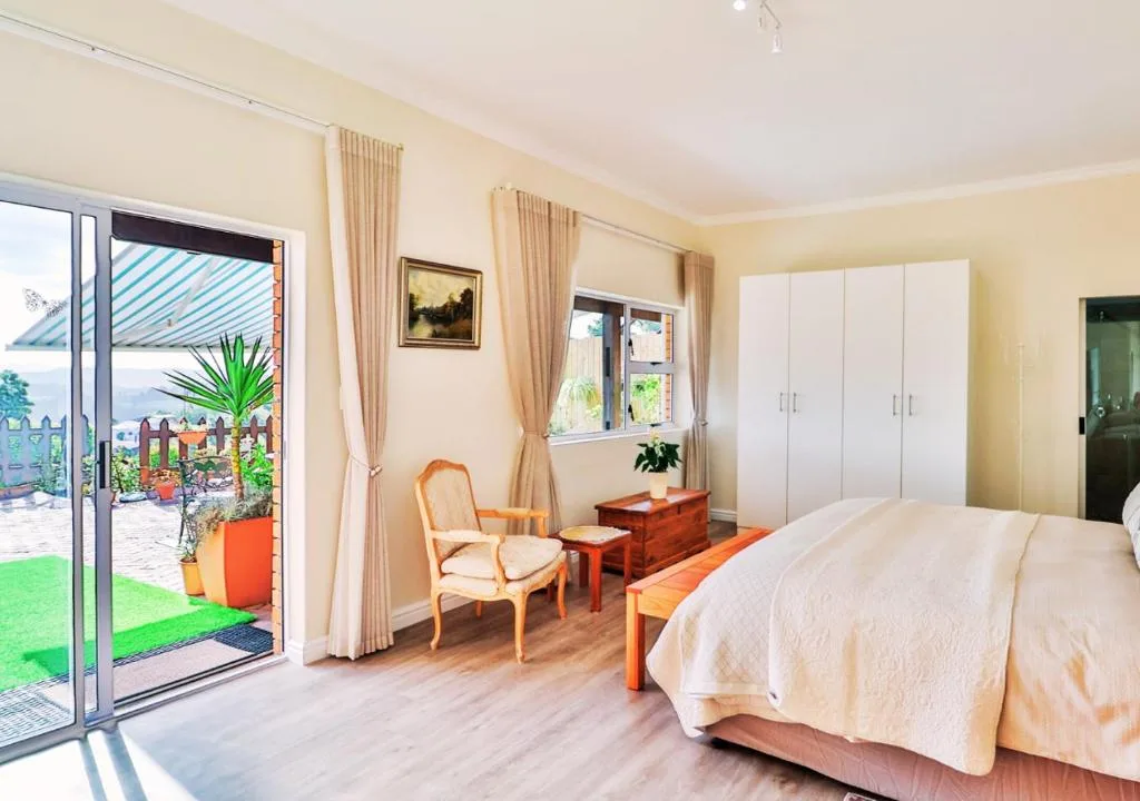 Bright spacious bedroom with large bed and garden views through patio doors