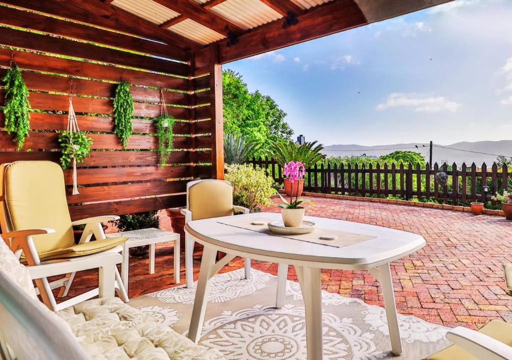 Covered patio with outdoor seating, mountain views, and flowering plants