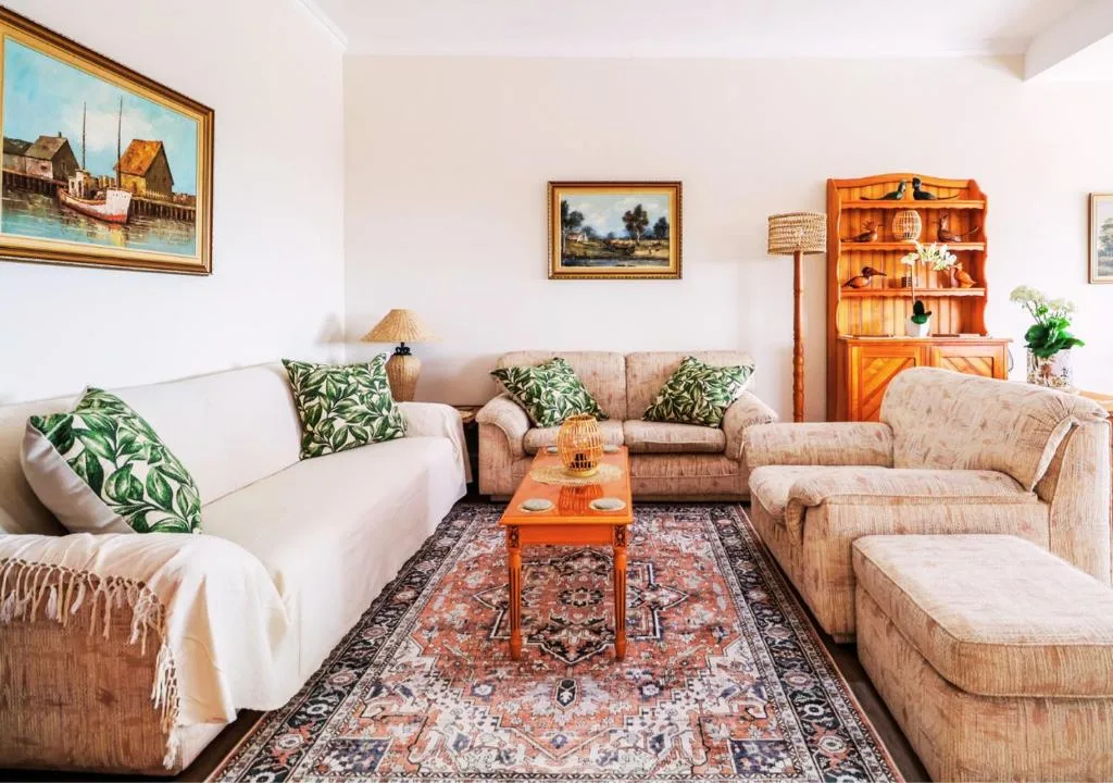 Spacious lounge with comfortable seating, framed artwork, and warm wooden decor