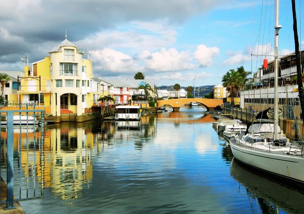 Colourful waterfront buildings and sailboats on Knysna lagoon