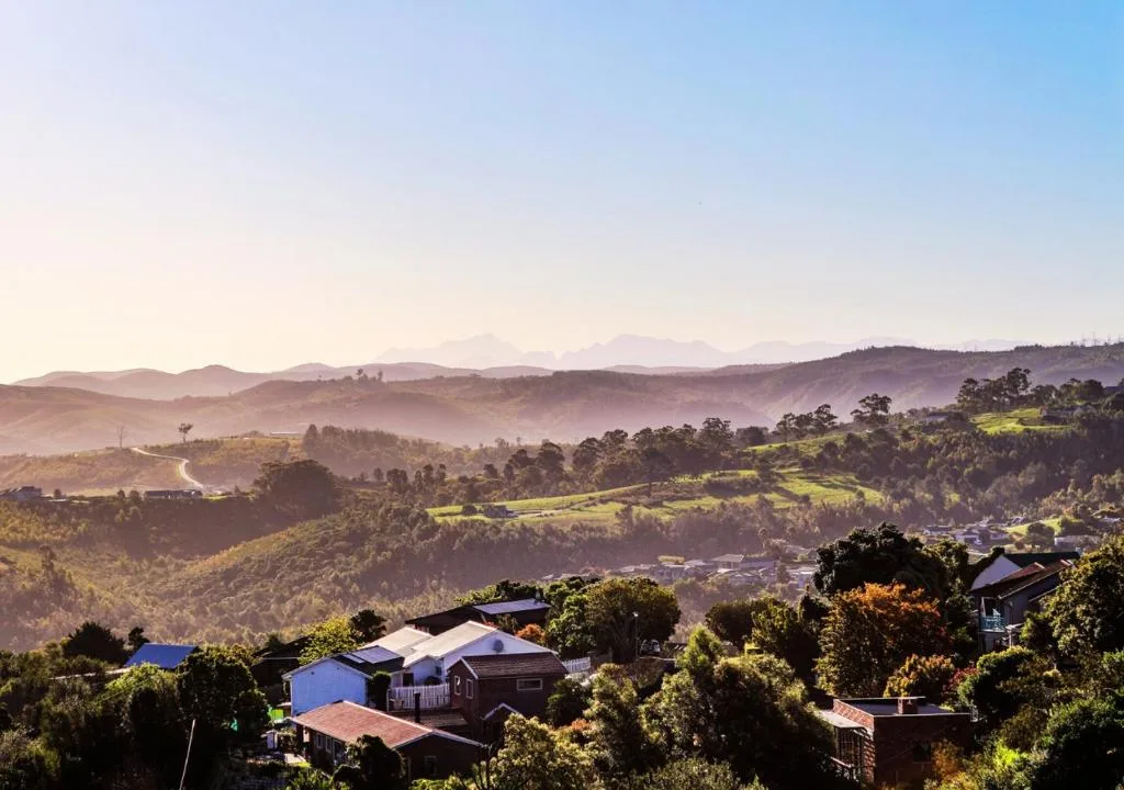 Panoramic valley and mountain landscape with lush green hills and distant peaks