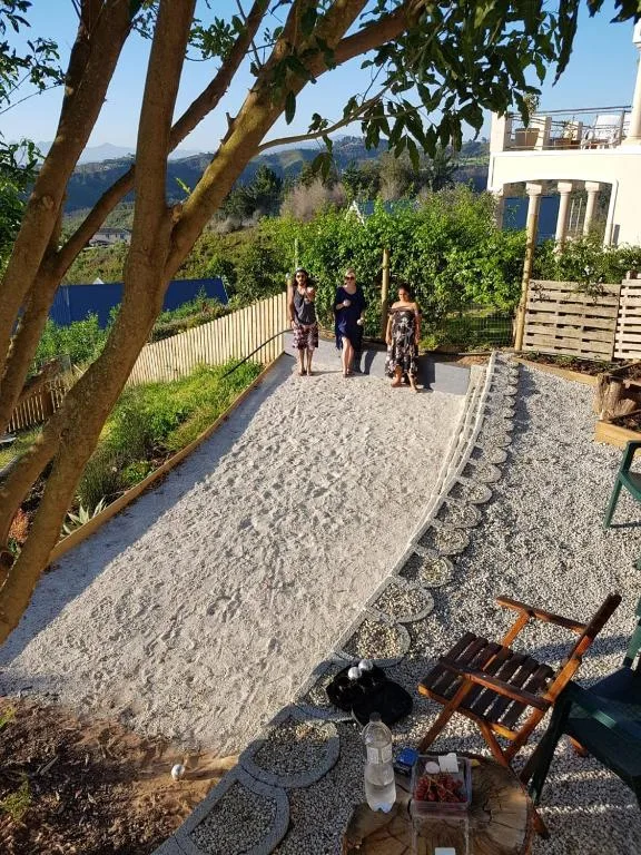 Gravel patio with seating, mature trees, and mountain views beyond
