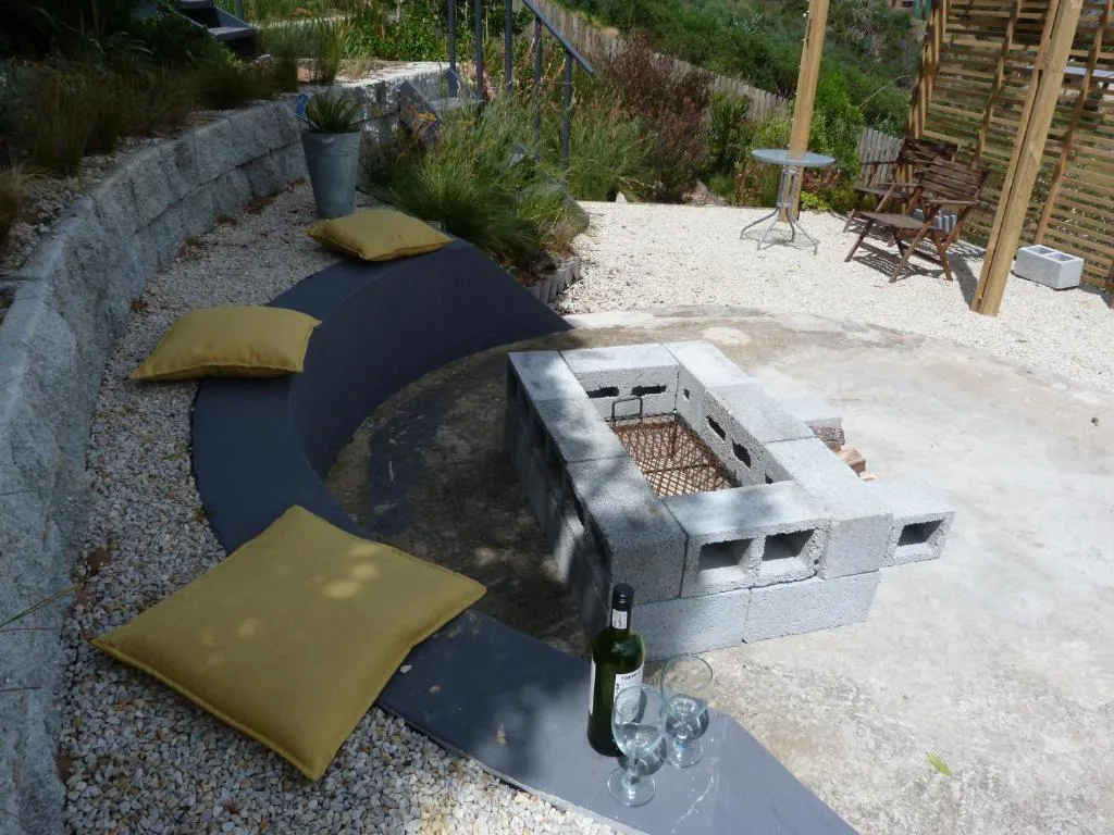 Outdoor deck area with seating, braai, and garden surroundings
