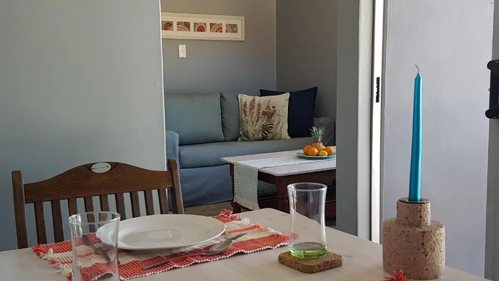 Open-plan dining area with set table and lounge visible beyond