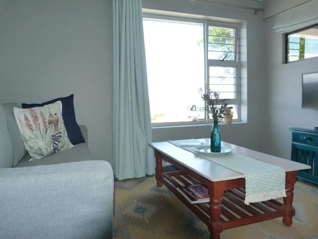 Bright lounge with sofa, coffee table, and ocean view through windows