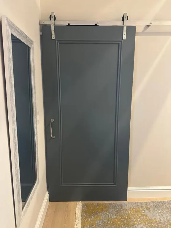 Modern sliding barn door in charcoal gray with polished hardware