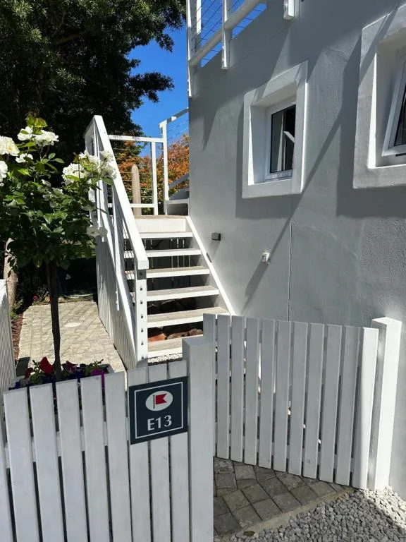 Modern gray apartment building with white stairs and entrance gate
