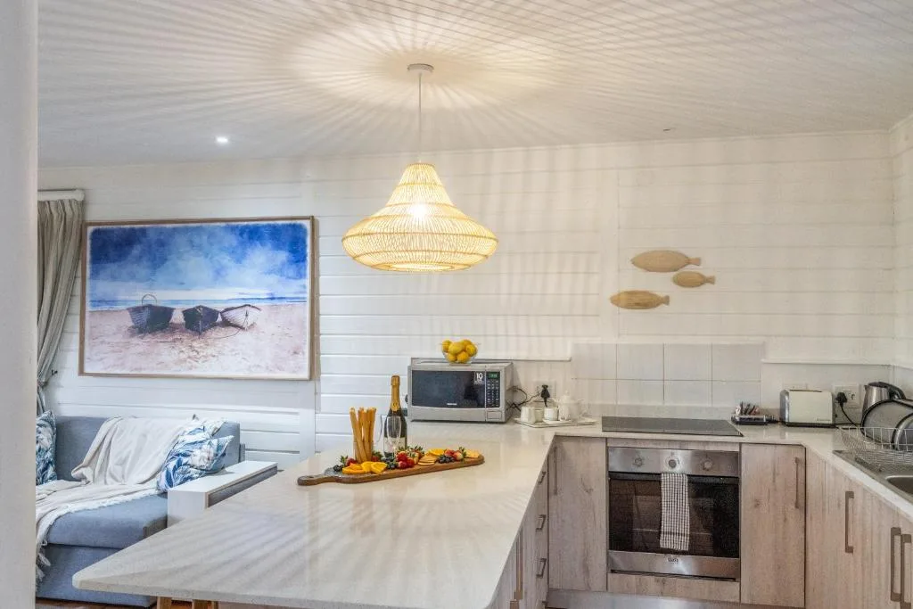 Modern kitchen with wooden cabinetry, stainless steel oven, and woven pendant light