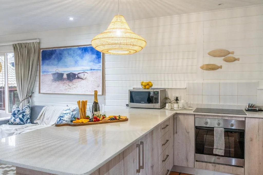 Modern kitchen with white countertop, wooden cabinetry, and pendant lighting