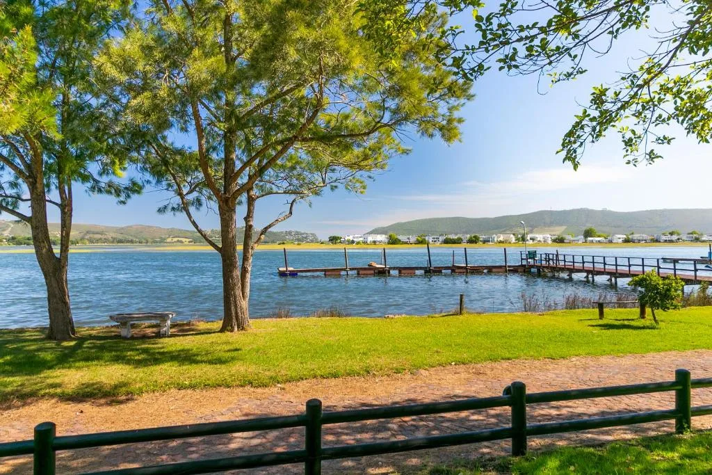 Scenic waterfront view with lagoon, mountains, and wooden jetty