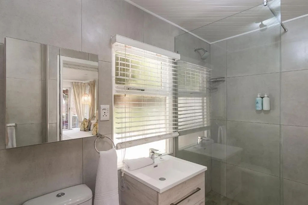 Modern bathroom with vanity, toilet, and frameless glass shower enclosure