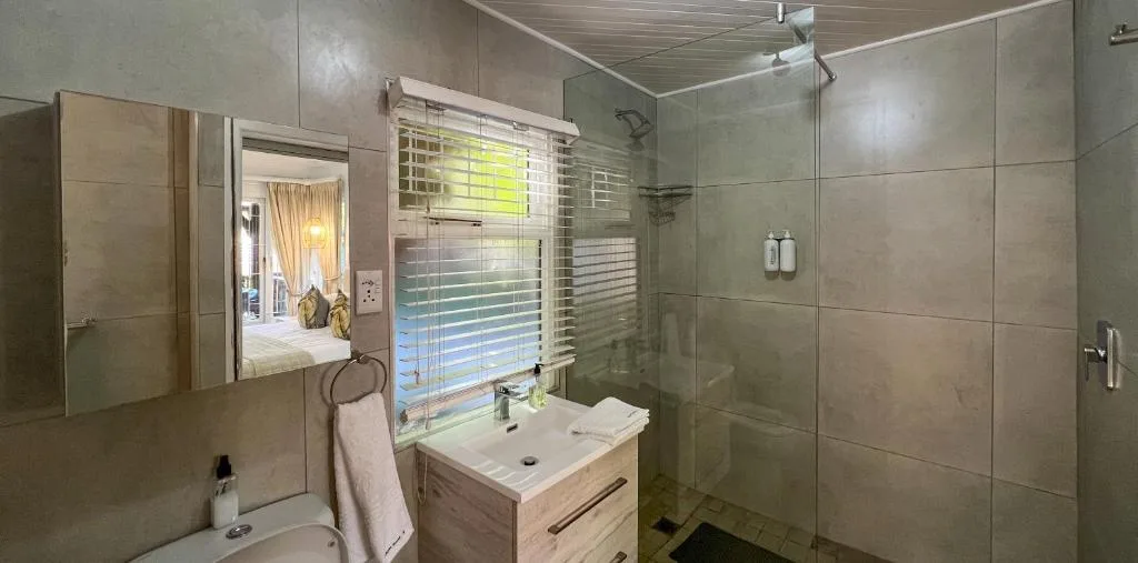 Modern bathroom with walk-in shower, vanity sink, and mirror cabinet