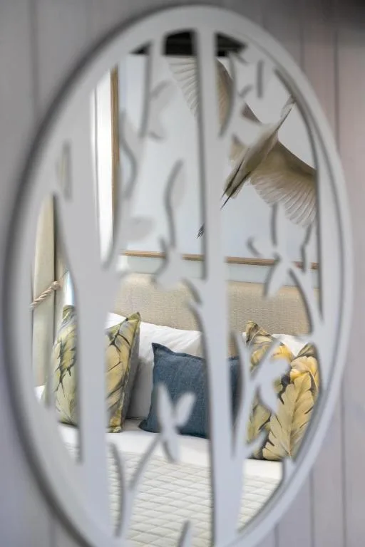 Bedroom view through decorative oval window showing bed with yellow pillows