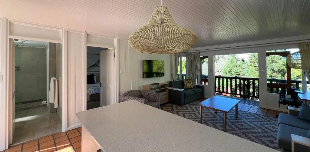 Spacious bedroom with ensuite bathroom and deck access overlooking garden