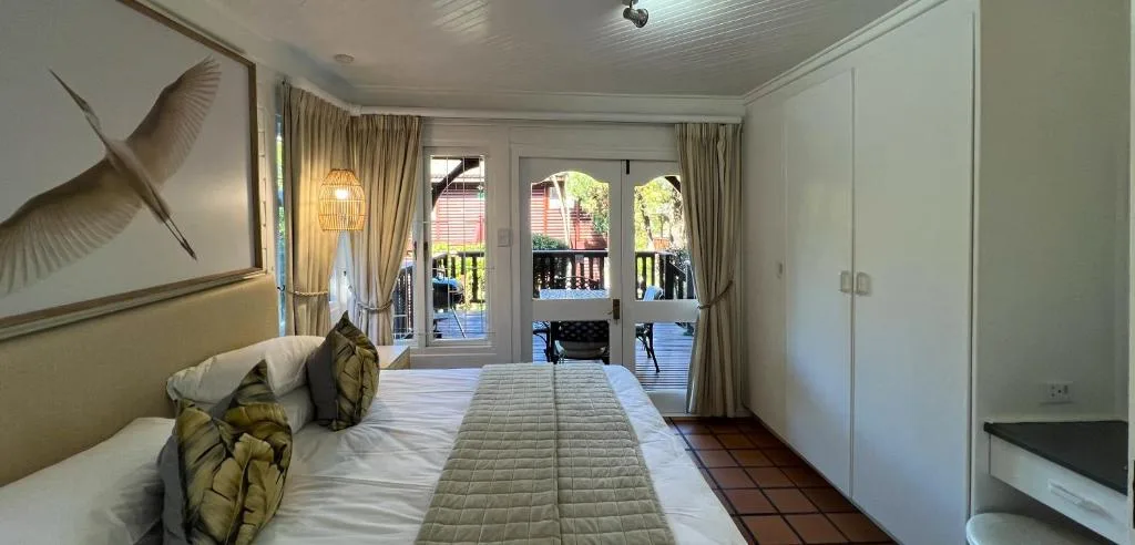 Spacious bedroom with queen bed, deck access, and contemporary wall art