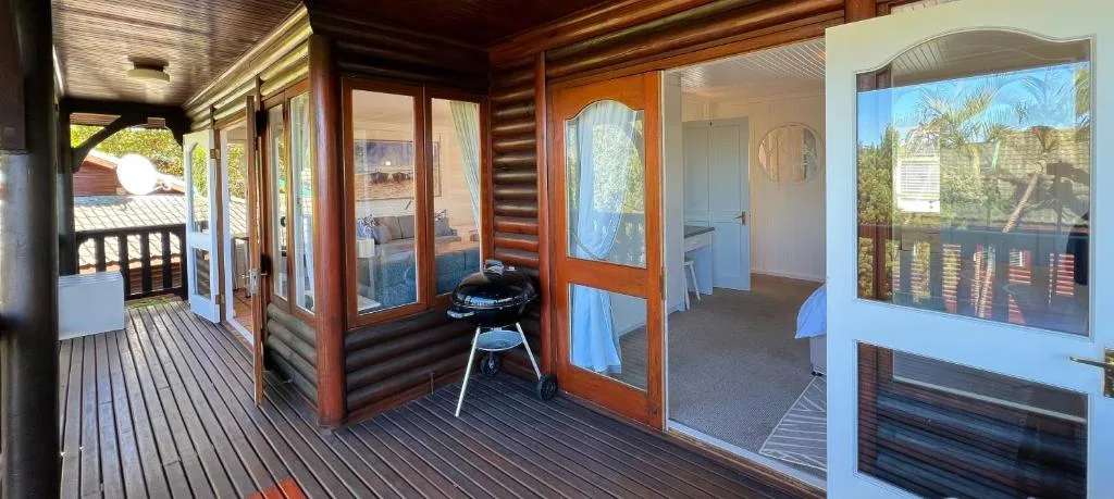 Wooden deck with braai and garden views, doors to interior spaces