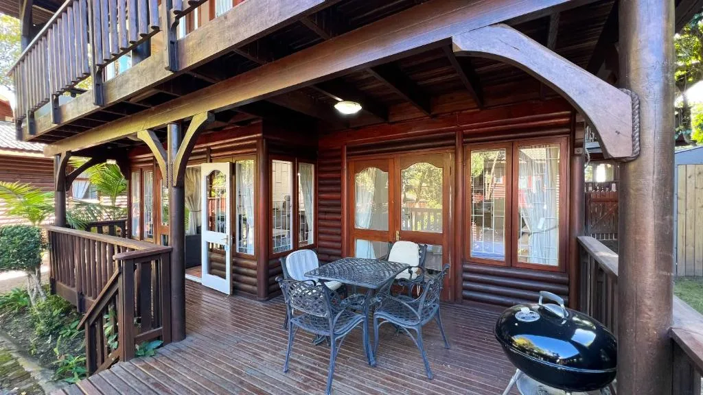Wooden deck with outdoor seating, braai grill, and timber railings