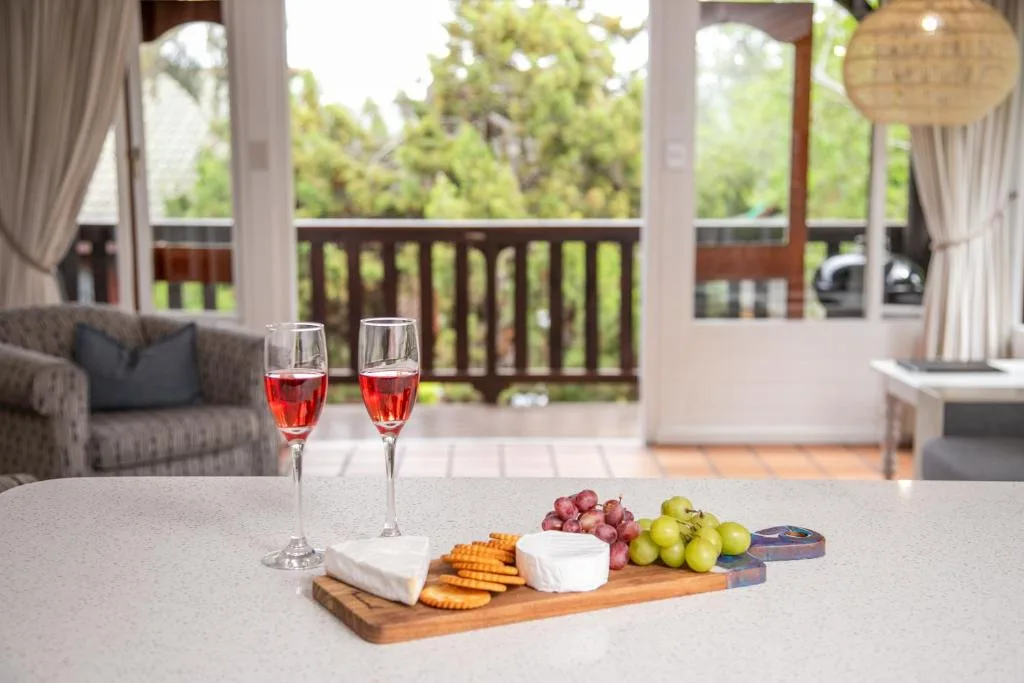 Charcuterie board with wine glasses and fresh fruit on table