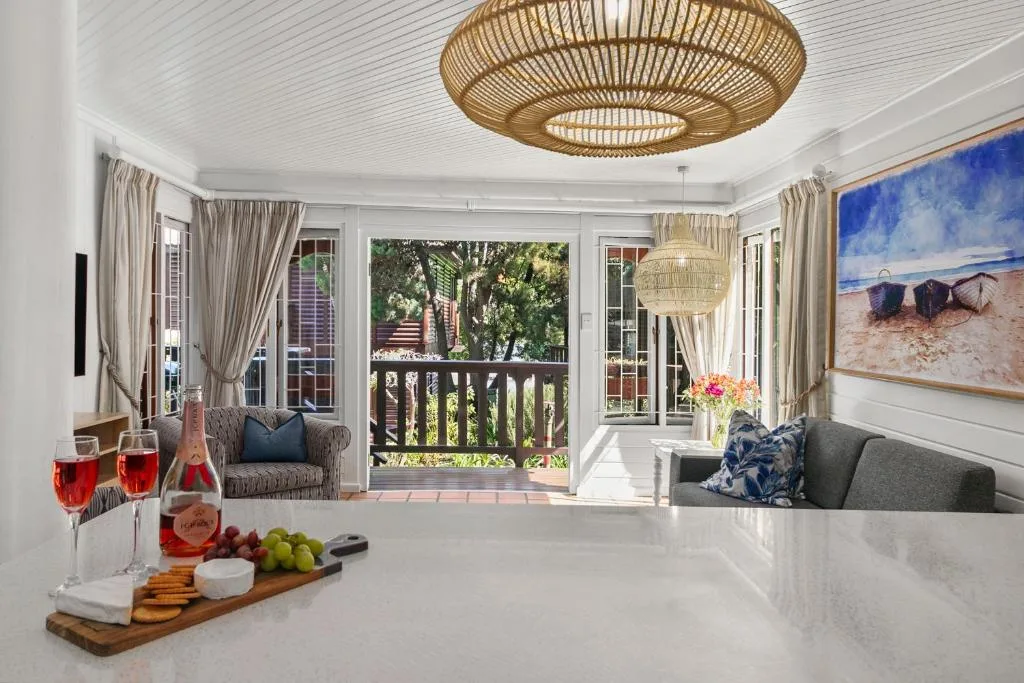 Open-plan lounge with comfortable seating, wine service, and deck access
