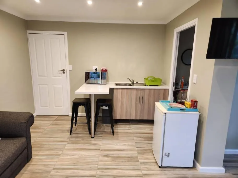 Open-plan kitchenette with compact appliances and bar seating area