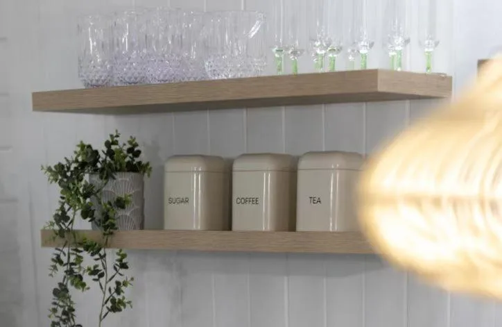 Kitchen shelves with glassware, storage canisters, and trailing plant décor