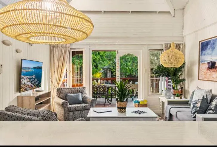 Bright open-plan lounge with coastal decor and garden views through large windows