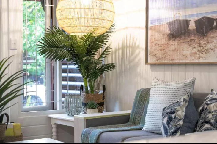 Bright lounge with coastal decor, woven pendant light, and comfortable seating