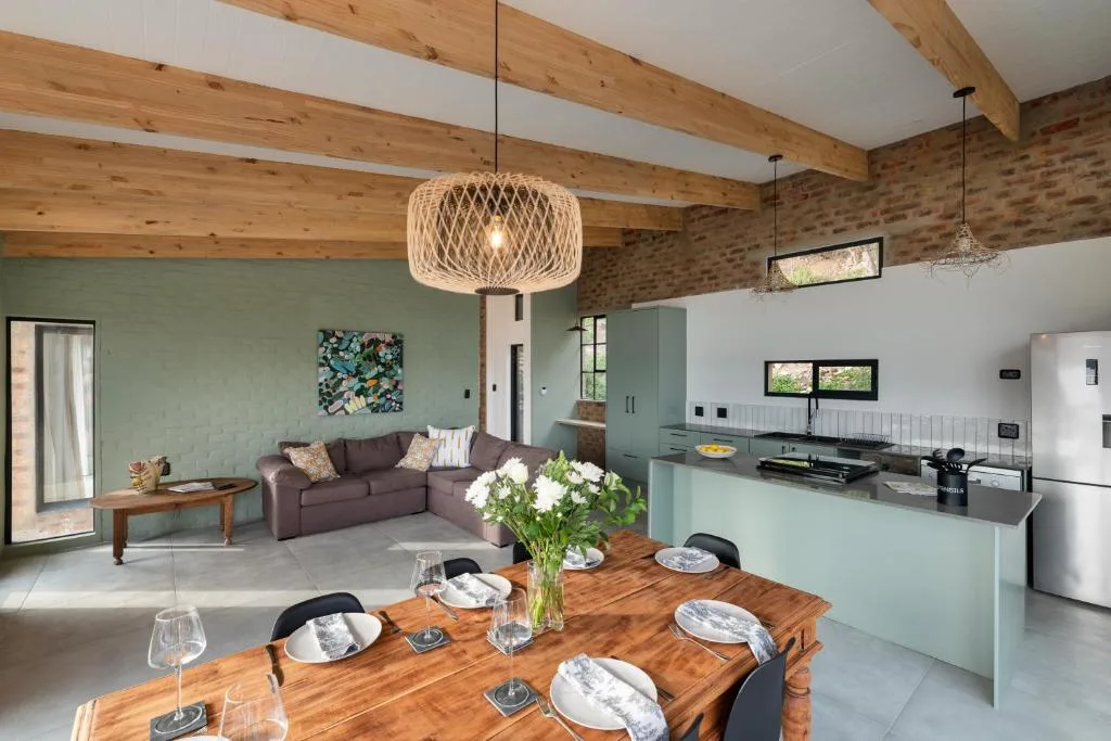 Open-plan dining area with wooden table, place settings, and fresh flowers