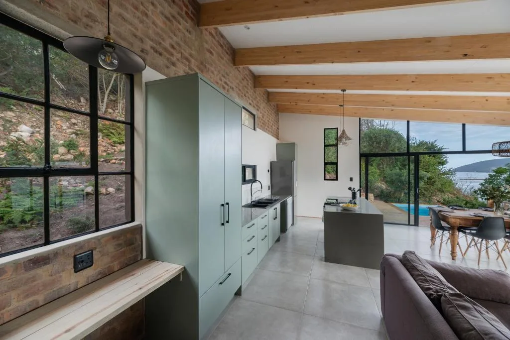 Modern lounge with kitchen area and lagoon views through large windows