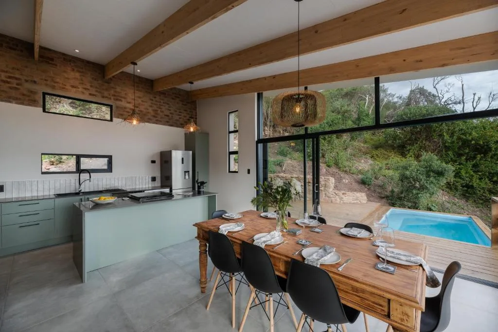 Modern open-plan living space with kitchen, dining table, and mountain views