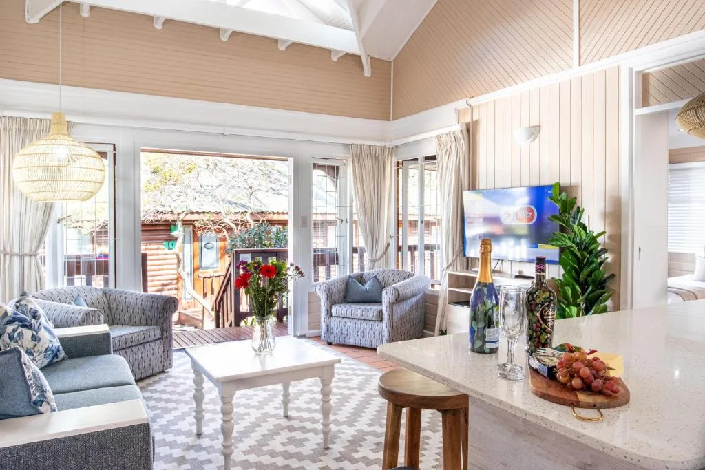 Bright open-plan lounge with comfortable seating and views to deck