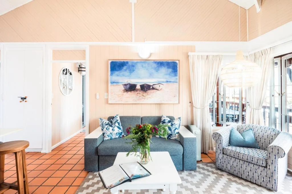 Bright living room with gray sofa, coastal artwork, and ocean view doors