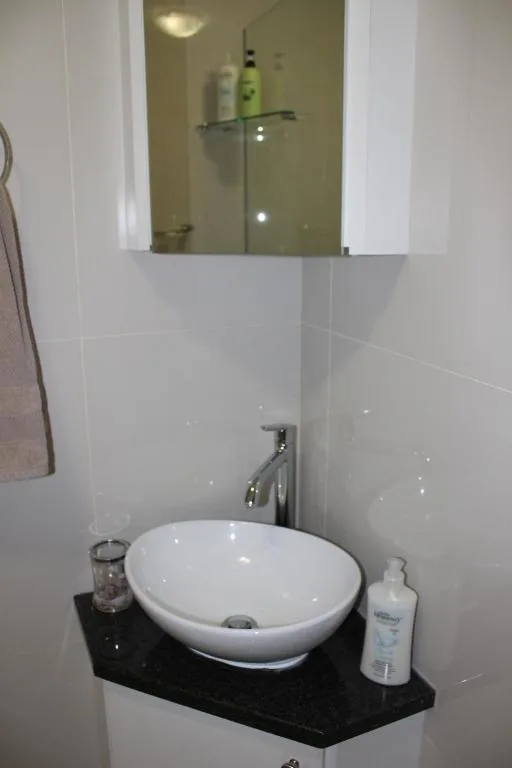 Modern bathroom with round white basin sink and mirror cabinet