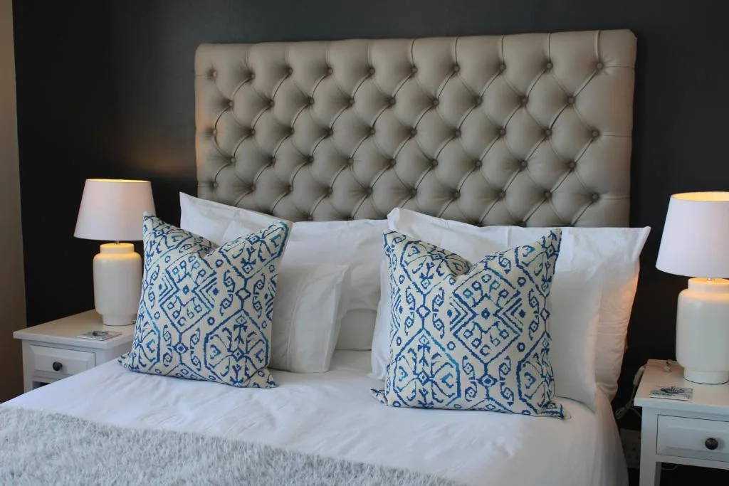 Luxurious bedroom with tufted headboard and blue patterned pillows