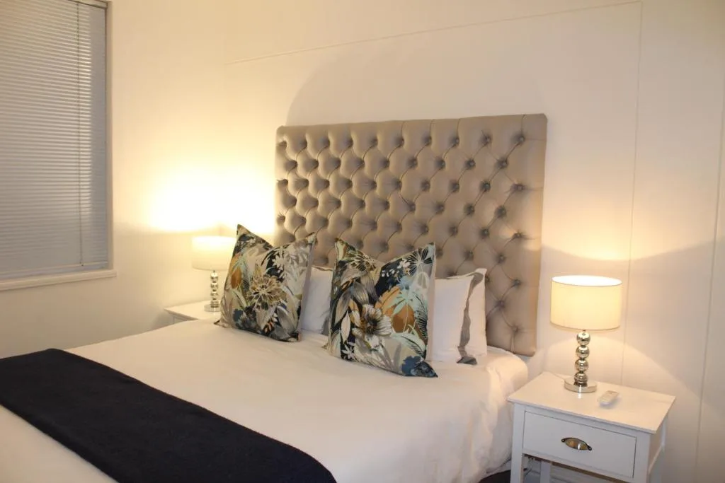 Bright modern bedroom with upholstered headboard and decorative pillows