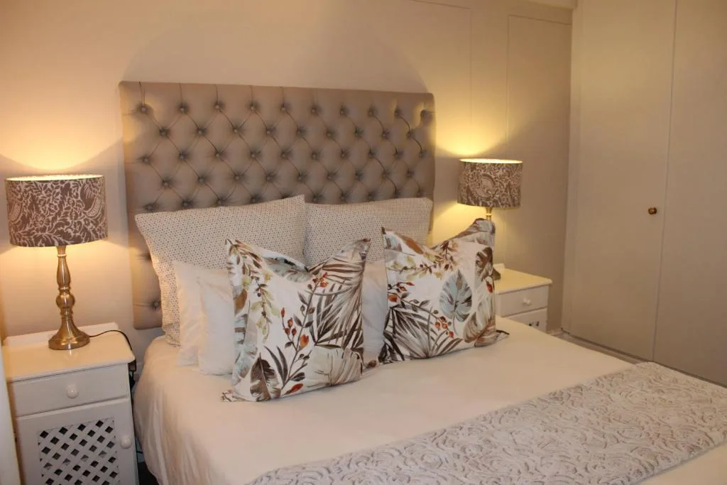 Elegantly styled bedroom with tufted headboard and botanical patterned pillows