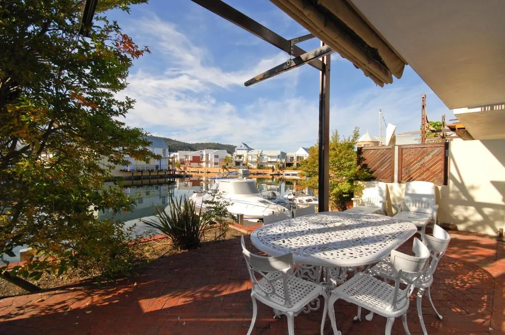 Waterfront deck with dining table overlooking Knysna Quays and lagoon