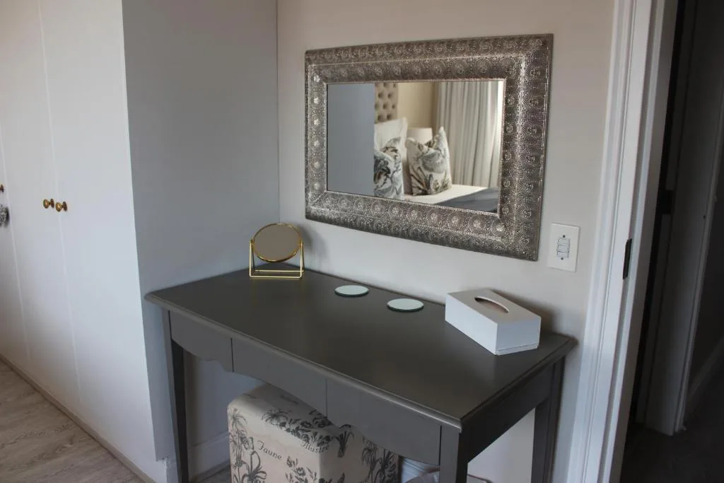 Bedroom vanity with decorative mirror, round mirror, and toiletries
