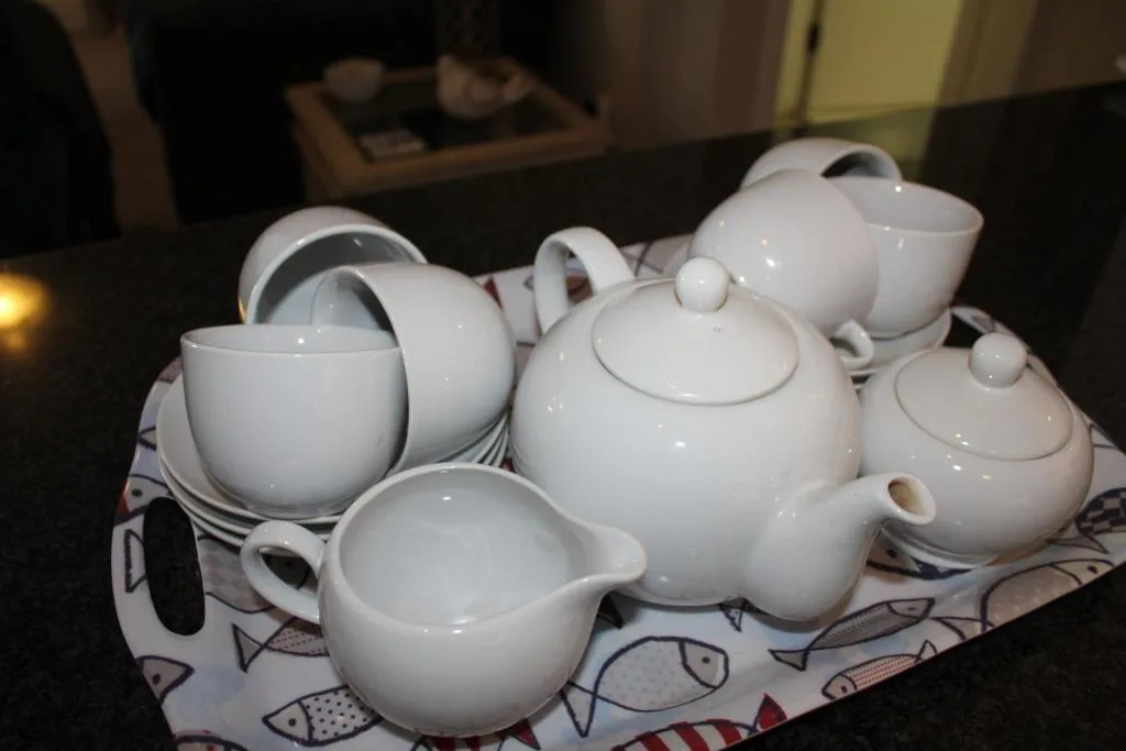 White ceramic tea service set with teapots and cups on display